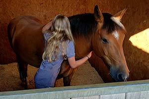 Disabled girl hugging horse preparing to go rising 