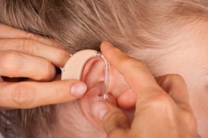 woman fitting a hearing aid