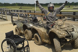 Sportability a muddy quadbike rider and wheelchair