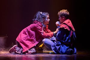 woman and boy performing onstage during assisted performance