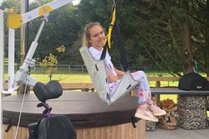 Ella getting into her hot tub at the accessible holiday accommodation and mindfulness retreat in West Sussex